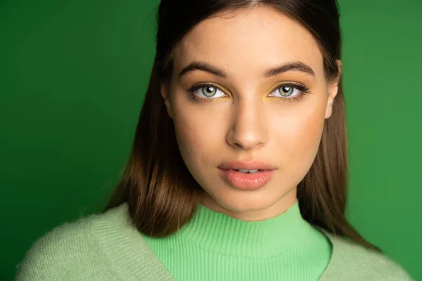 stock image Portrait of teen girl with makeup looking at camera isolated on green 