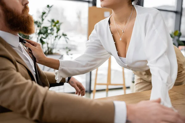 stock image cropped view of african american woman pulling tie while seducing bearded coworker in office 