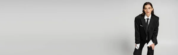 Модна Жінка Чорному Оверсайз Костюмі Дивлячись Далеко Стоячи Ізольовано Сірому — стокове фото