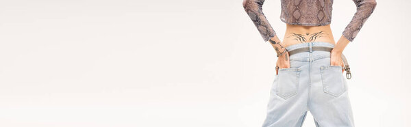 Cropped view of nonbinary person holding hands in pockets isolated on white, banner 