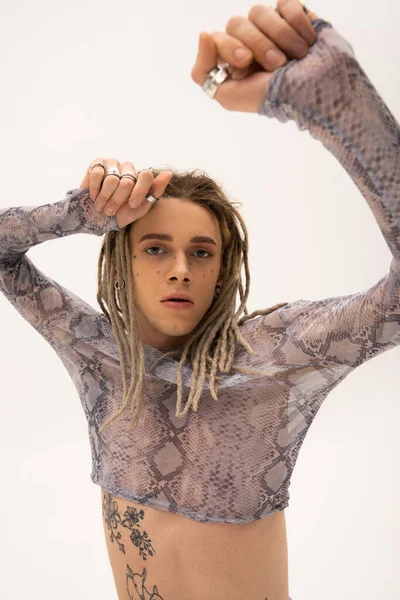 Tattooed queer person in stylish crop top with animal print isolated on white 