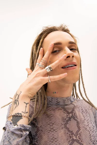 Positive tattooed queer person looking at camera isolated on white 