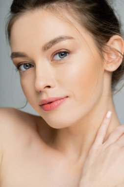 Portrait of young fair haired model looking at camera isolated on grey 