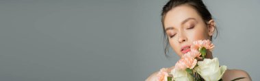 Pretty fair haired woman holding flowers isolated on grey, banner 
