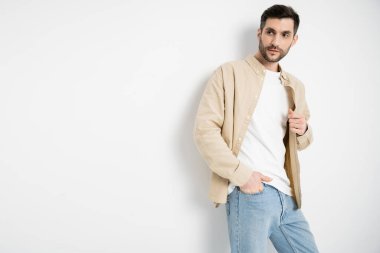 Man in casual clothes and jeans posing on white background 