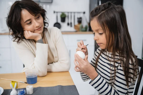 stock image Preteen girl coloring Easter egg near mom in kitchen 