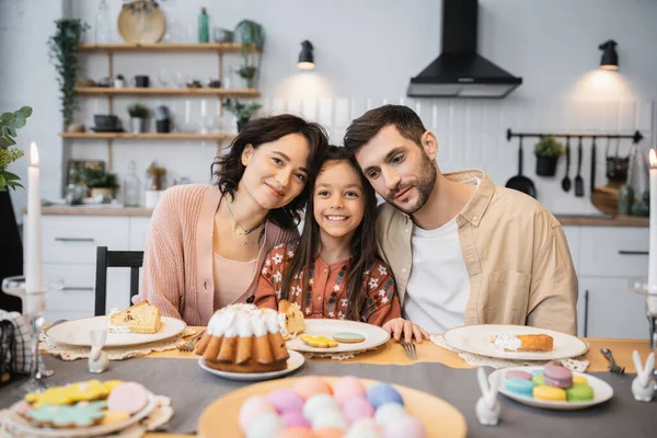 stock image Cheerful parents and kid sitting near festive Easter dinner in kitchen 