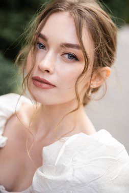 portrait of gorgeous young bride in white wedding dress looking at camera 