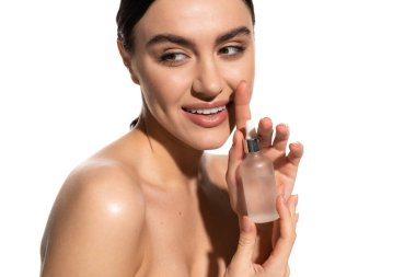 cheerful young woman with natural makeup holding bottle with serum isolated on white 
