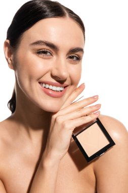 happy young woman with bare shoulders holding neutral beige face powder isolated on white 