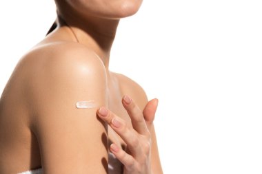 cropped view of young woman applying lotion on body isolated on white  clipart