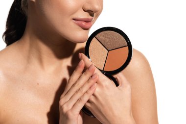 cropped view of young woman with bare shoulder holding bronzer and highlighter palette isolated on white  clipart