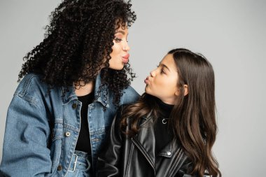 Trendy mother and kid pouting lips isolated on grey 