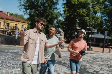 Andrews 'un Kyiv' e inişi sırasında çok kültürlü turistlerle konuşurken güneş gözlüklü tur rehberi el kol hareketi yapıyor.