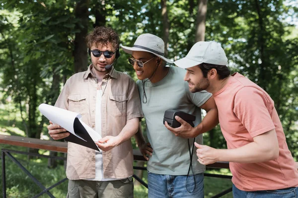 Guide Headset Sunglasses Showing Clipboard Route Multicultural Tourists Fence City — Stock Photo, Image
