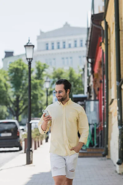 Hombre Morena Gafas Sol Usando Teléfono Inteligente Mientras Camina Por — Foto de Stock