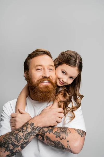 Hija Preadolescente Abrazando Padre Tatuado Mientras Sonríen Juntos Aislados Gris —  Fotos de Stock