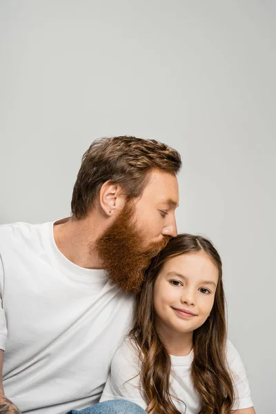 Бородатый Мужчина Белой Футболке Целует Улыбающуюся Дочь Изолированную Серой — стоковое фото