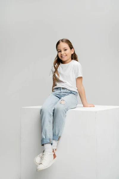 Vrolijk Kind Shirt Jeans Zittend Kubus Geïsoleerd Grijs — Stockfoto