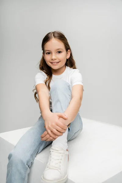 Unbekümmertes Mädchen Jeans Und Shirt Sitzt Auf Weißem Würfel Isoliert — Stockfoto