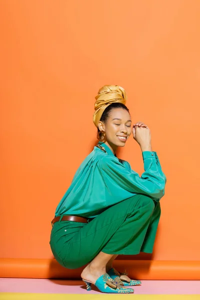 Dertsiz Afrikalı Amerikalı Kadın Parlak Elbiseli Renkli Arka Planda Oturuyor — Stok fotoğraf