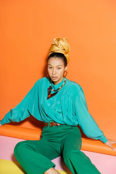 Giyimli Afro Amerikan Modeli Renkli Arka Planda Otururken Kameraya Bakıyor — Stok fotoğraf