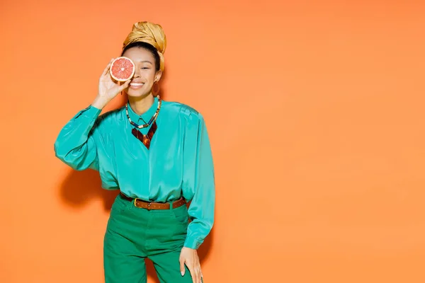 Turuncu Arka Planda Greyfurt Tutan Yaz Kıyafeti Içinde Gülümseyen Afro — Stok fotoğraf