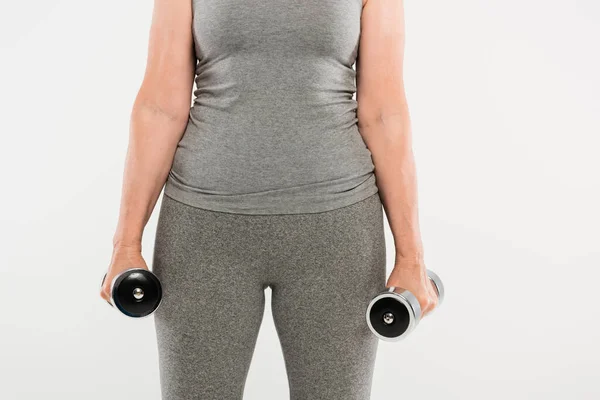 운동복을 여자가 회색에 고립된 덤벨을 가지고 운동하는 — 스톡 사진