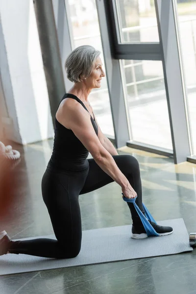 Siyah Taytlı Kolsuz Tişörtlü Neşeli Yaşlı Sporcu Bayanın Fitness Minderinde — Stok fotoğraf