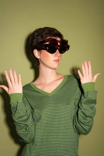 Brunette Woman Striped Jumper Wearing Several Trendy Sunglasses Green Background — Stock Photo, Image
