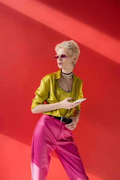 Dövmeli Güneş Gözlüklü Kadın Carmine Pembe Akıllı Telefon Kullanıyor — Stok fotoğraf
