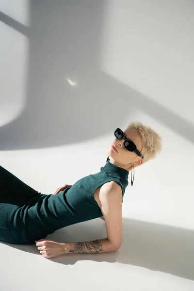 Tätowierte Frau Mit Sonnenbrille Und Kleid Posiert Auf Grauem Hintergrund — Stockfoto