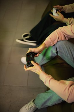 KYIV, UKRAINE - 13 Şubat 2023: Oyun kulübünde bulanık bir arkadaşla video oyunu oynayan adamın görüntüsü 
