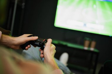 KYIV, UKRAINE - 13 Şubat 2023: Siber kulüpte bulanık TV 'nin yanında video oyunu oynayan adamın görüntüsü 