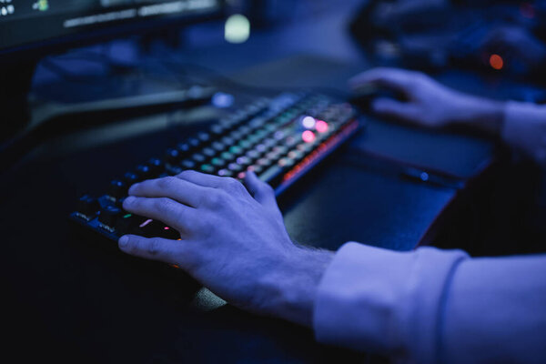 Cropped view of man playing video game on computer on cyber club
