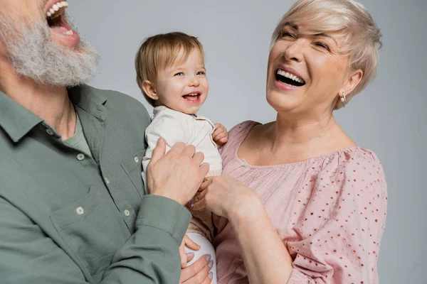 Rozweselona Para Śmiejąca Się Pobliżu Ukochanej Wnuczki Odizolowanej Szaro — Zdjęcie stockowe