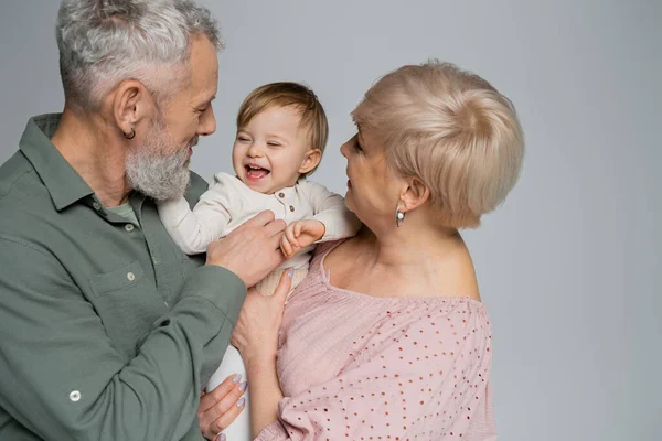 Счастливые Бабушки Дедушки Обнимают Смеющуюся Девочку Изолированную Серых — стоковое фото