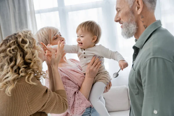 Zorgeloze Baby Aanraken Gezicht Van Moeder Buurt Gelukkig Grootouders Thuis — Stockfoto