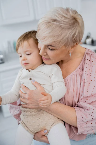 Middle Aged Woman Calming Embracing Upset Granddaughter Kitchen — Stock Photo, Image