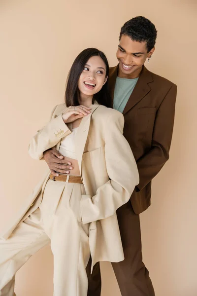 Elegante Africano Americano Uomo Abbracciando Spensierato Asiatico Donna Avorio Vestito — Foto Stock