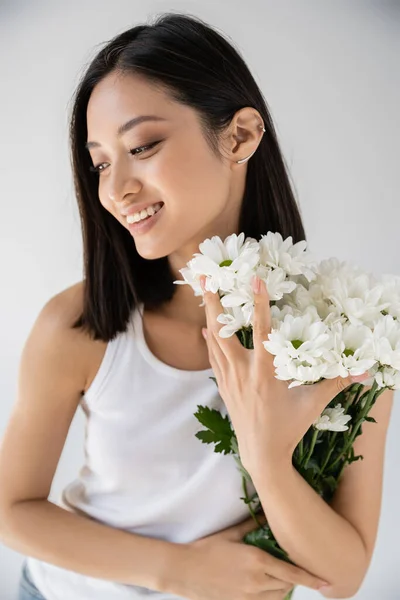 Μελαχρινή Ασιάτισσα Σκουλαρίκι Στο Μανίκι Χαμογελώντας Κοντά Λευκά Λουλούδια Απομονωμένα — Φωτογραφία Αρχείου