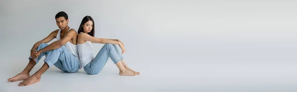 Longitud Completa Pareja Multiétnica Descalza Camisetas Sin Mangas Jeans Sentados — Foto de Stock