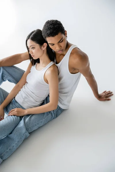 Vue Grand Angle Jeune Couple Interracial Débardeurs Blancs Jeans Assis — Photo
