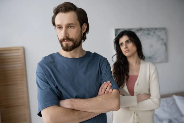 Sad Man Crossing Arms Blurred Girlfriend Bedroom Home — Stock Photo, Image