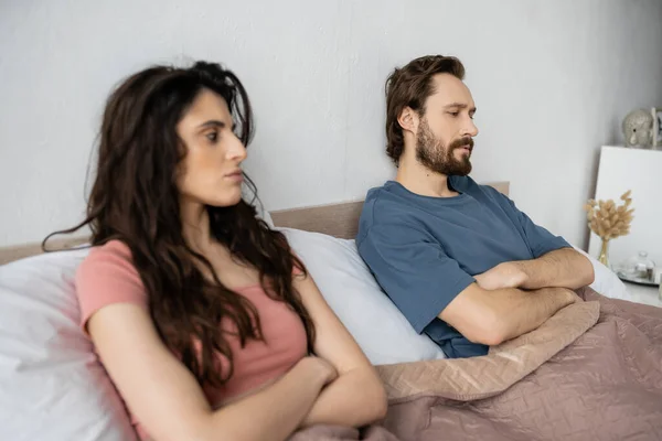 Dissatisfied Man Crossing Arms While Sitting Blurred Girlfriend Bed Home — Stock Photo, Image