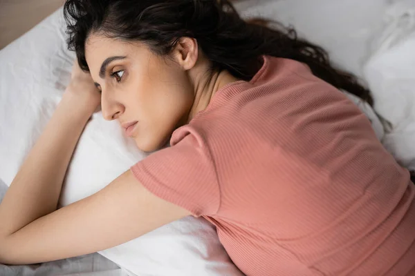 悲しいブルネット女性見ながら横にベッドで午前中 — ストック写真