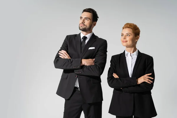 Serious Bearded Businessman Cheerful Redhead Businesswoman Crossing Arms Looking Away — Stock Photo, Image