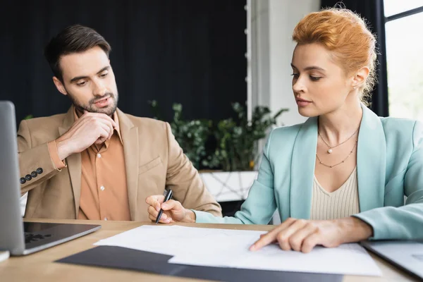Redhead Businesswoman Pointing Documents Thoughtful Colleague Office — Stock Photo, Image