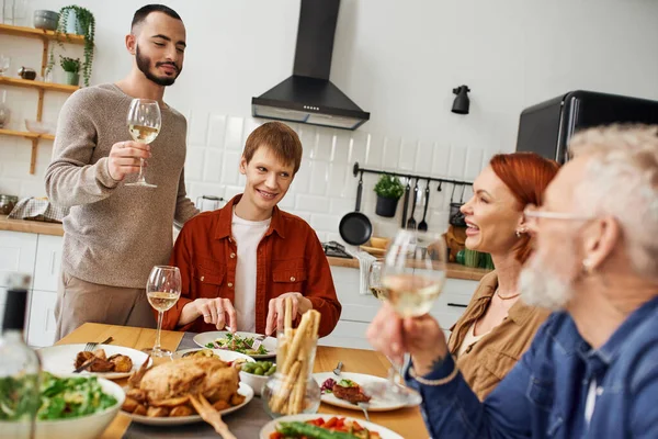 一家人在厨房吃饭的时候 满脸胡须的基佬在男朋友和快乐的父母身边品酒 — 图库照片