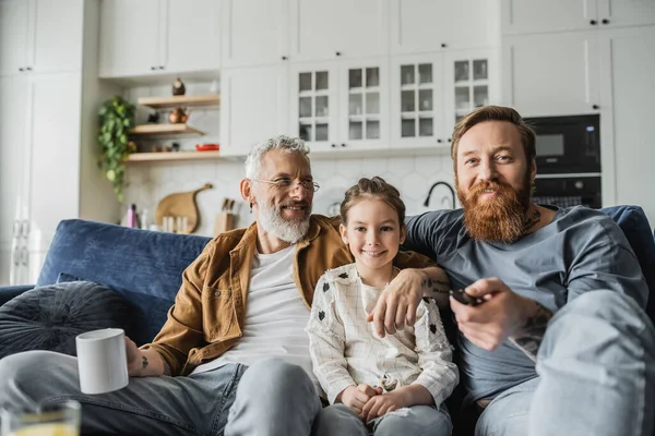 Positive Gay Parents Hugging Daughter While Watching Home — Stock Photo, Image